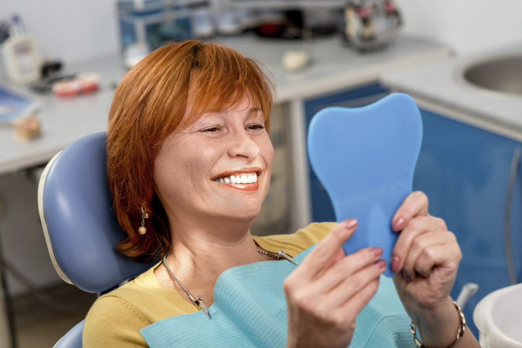 woman smiling after recieving dental implants